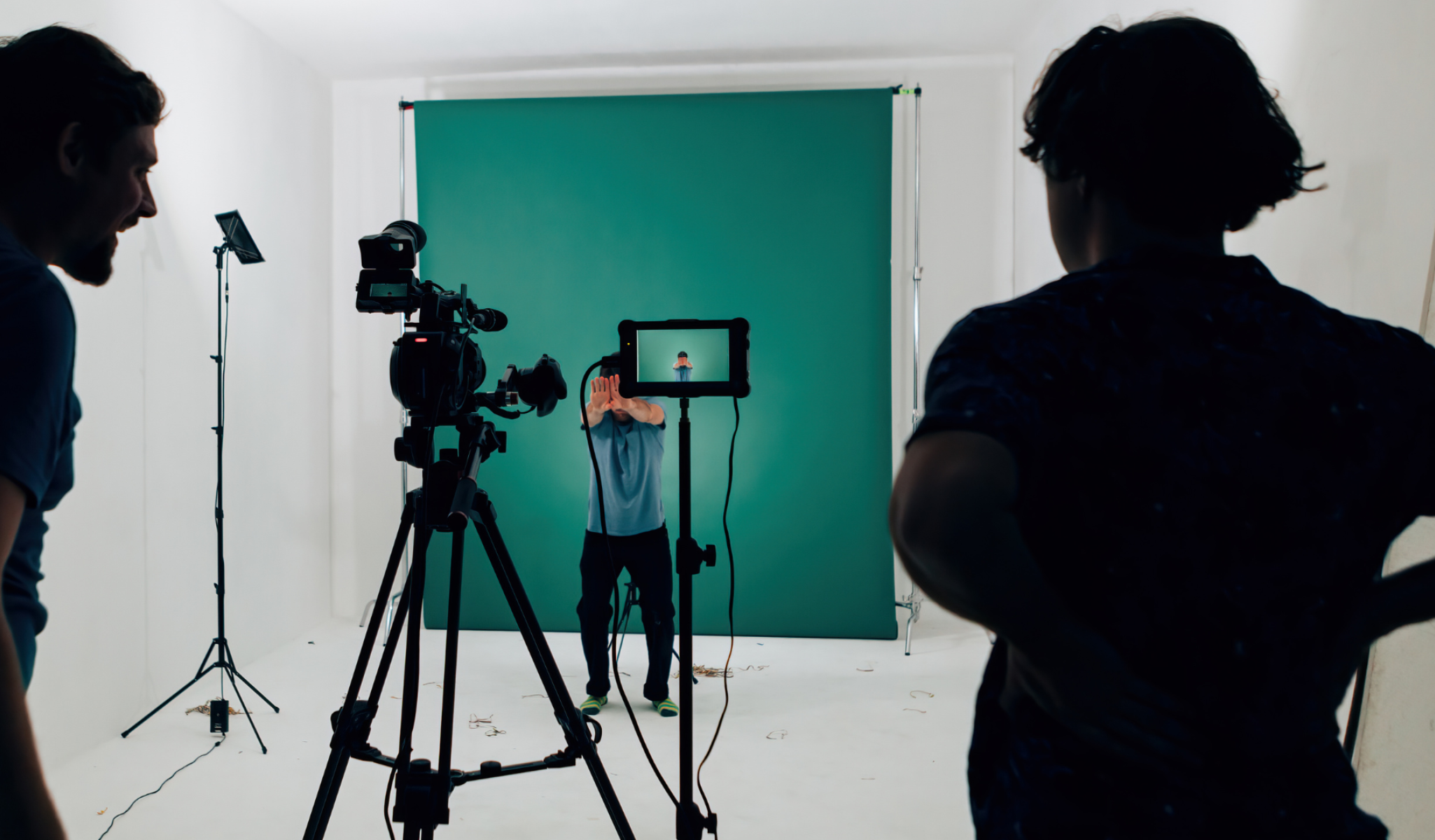 man standing in front of a camera in a green room